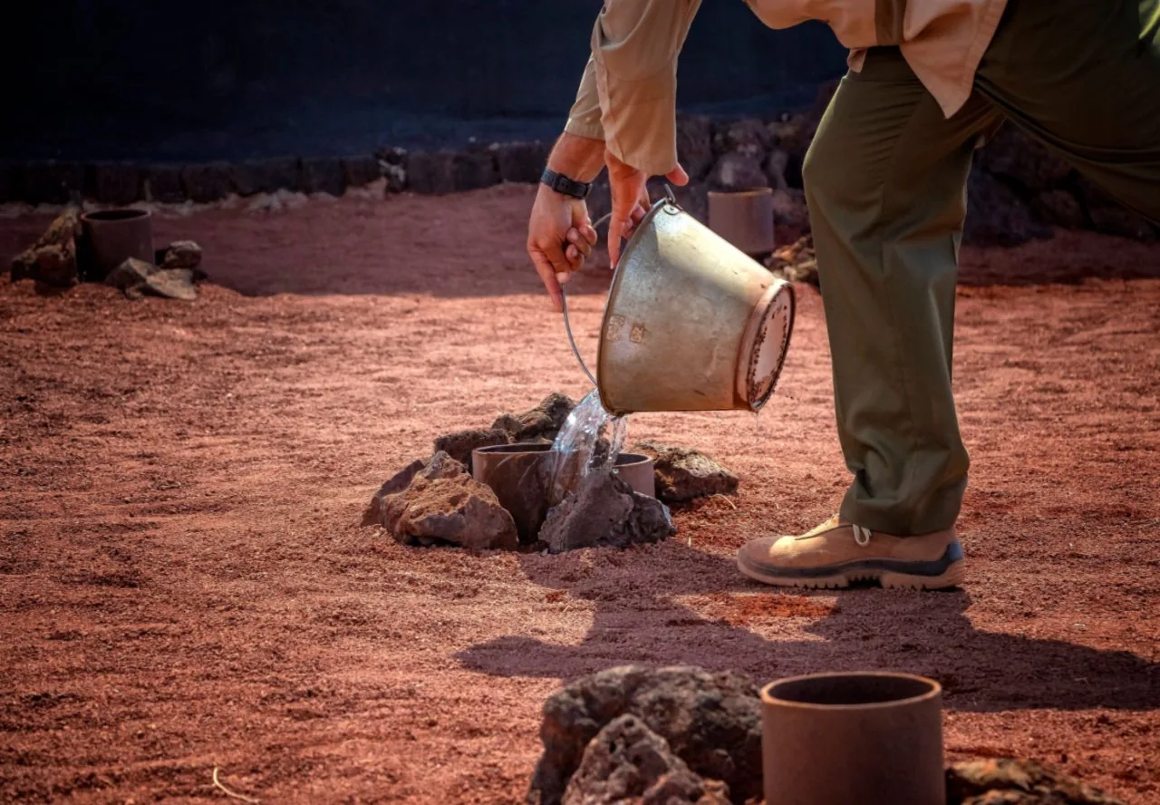 A guide pouring water into a borehole at the Islote de Hilario for the steam demonstration