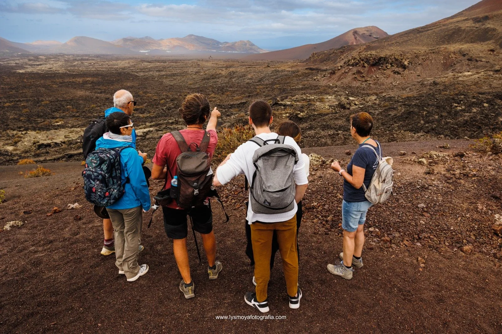A guided group looking out over the volcanic plain, one walker pointing to the horizon