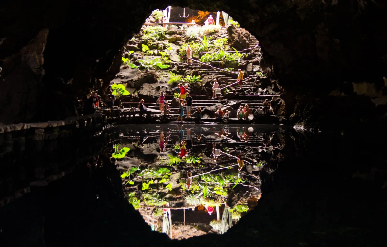 The illuminated planting and walkways of Jameos del Agua reflected in its underground lagoon