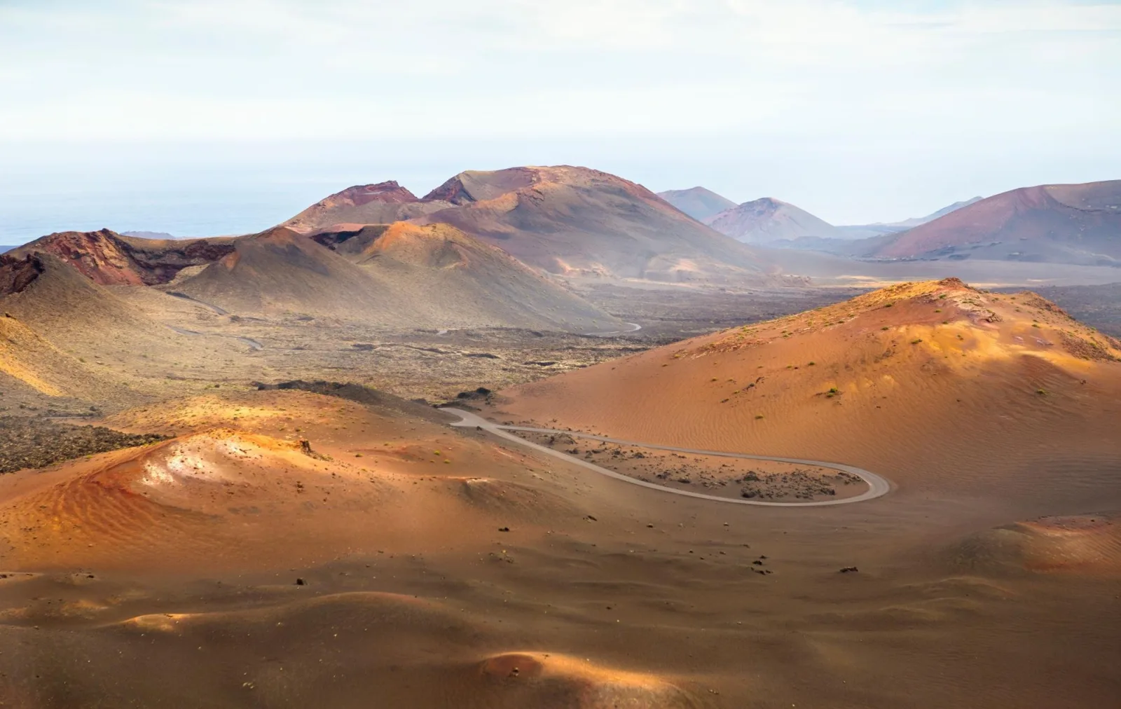 The Ruta de los Volcanes winding between ochre and red cones across the Timanfaya crater field