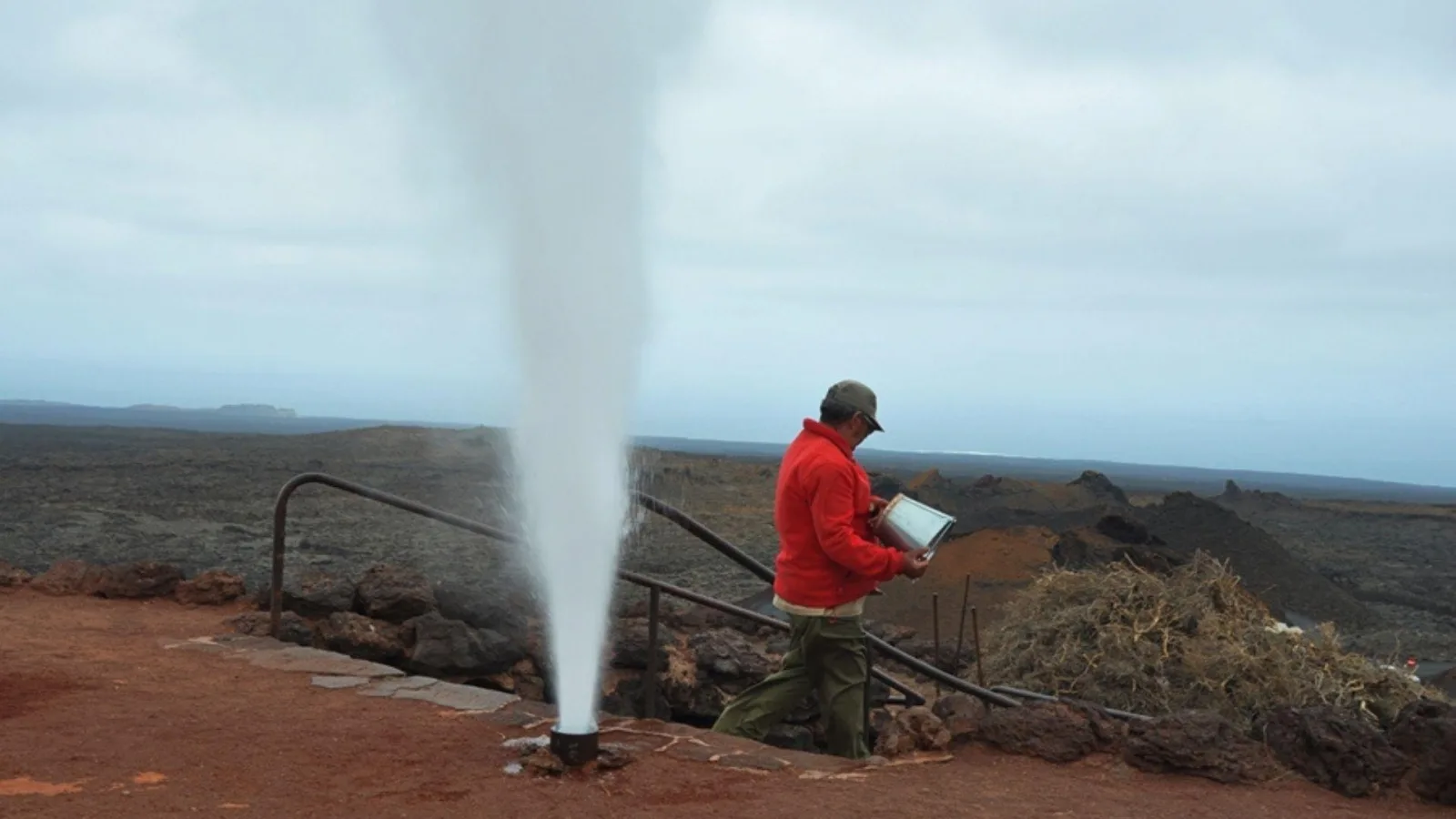 A guide in a red shirt firing off the steam geyser at the Islote de Hilario