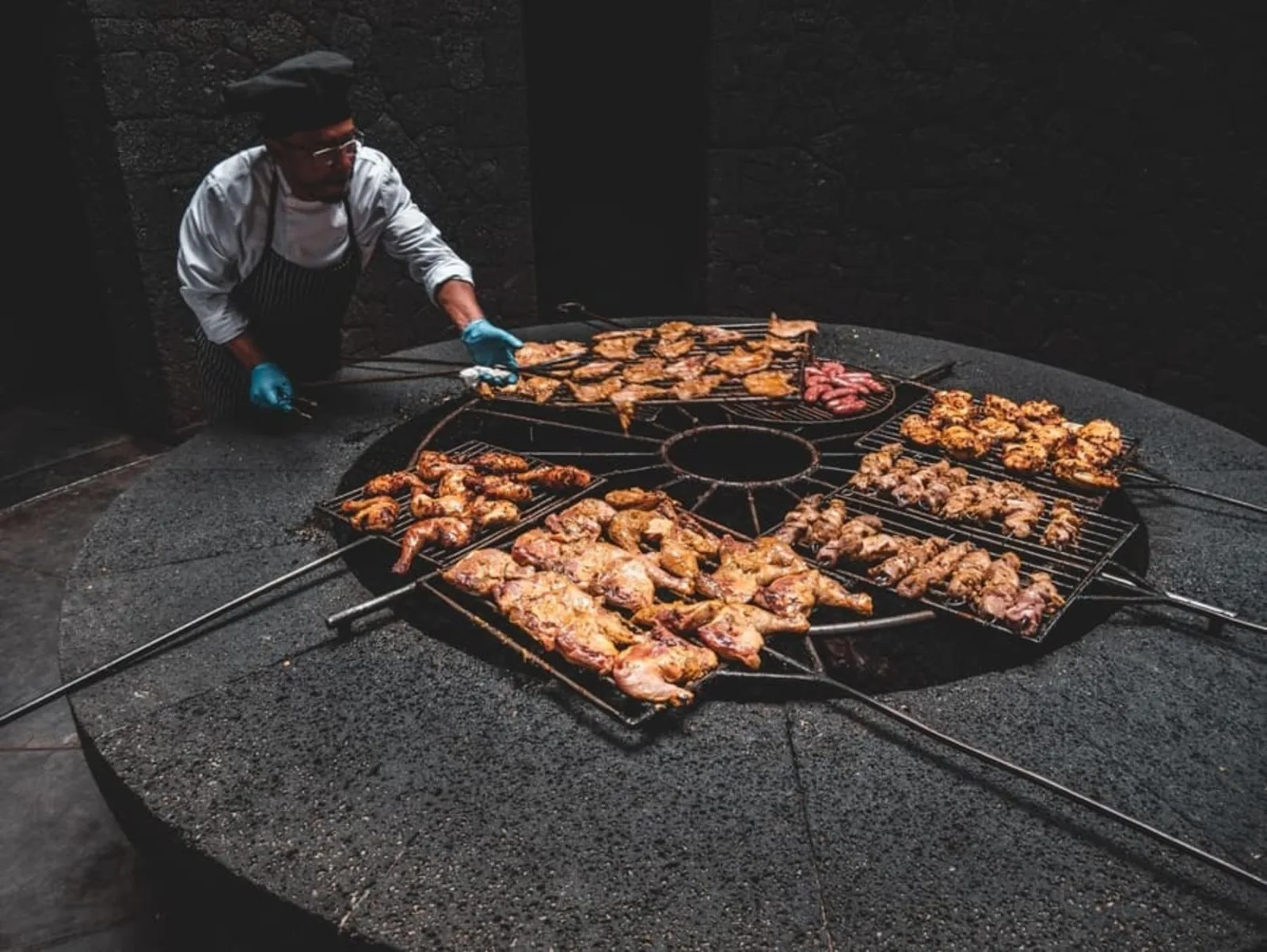 A chef laying skewers across the circular grill set over the volcano's heat vent