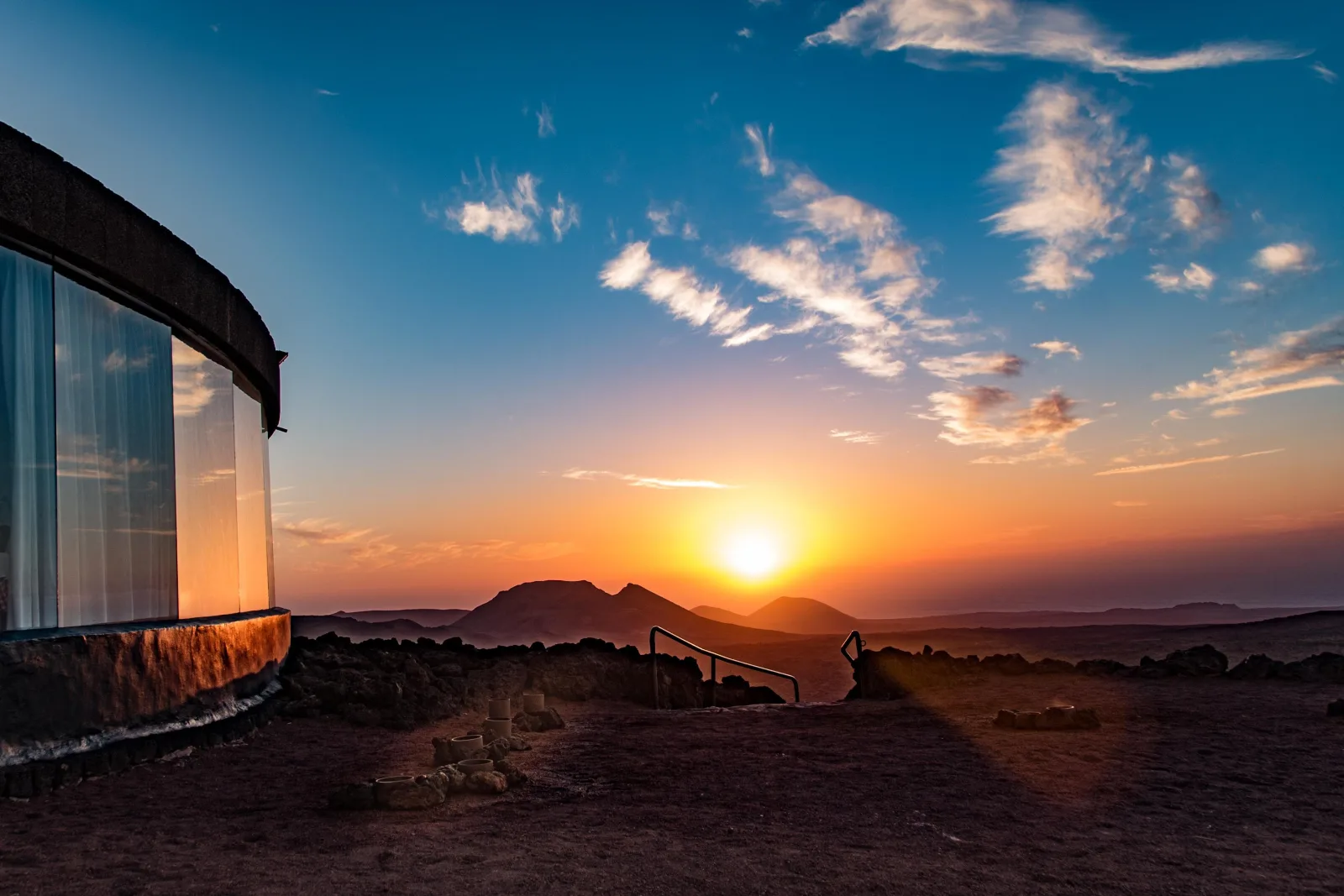 The curved glass of the El Diablo dining room looking out to the sunset over the crater field